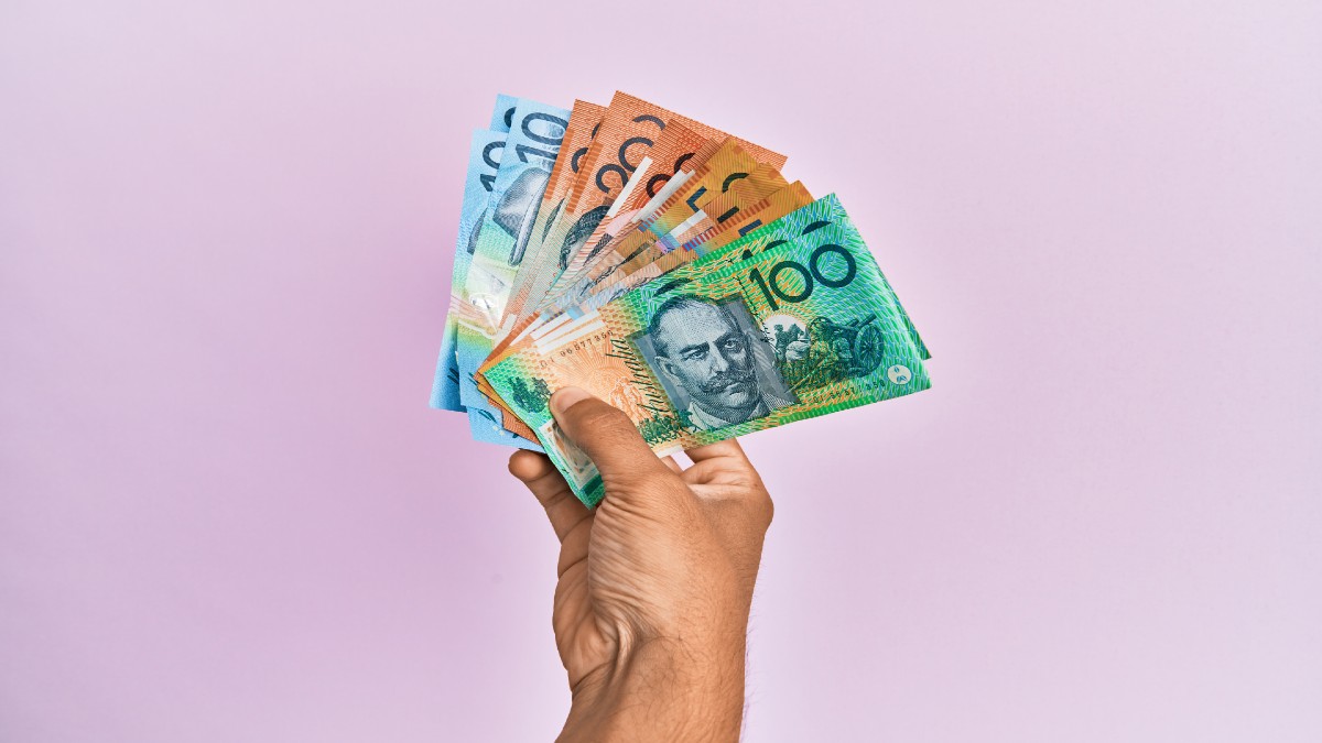 Hispanic-hand-holding-australian-dollars-banknotes-isolated-pink-background.jpg